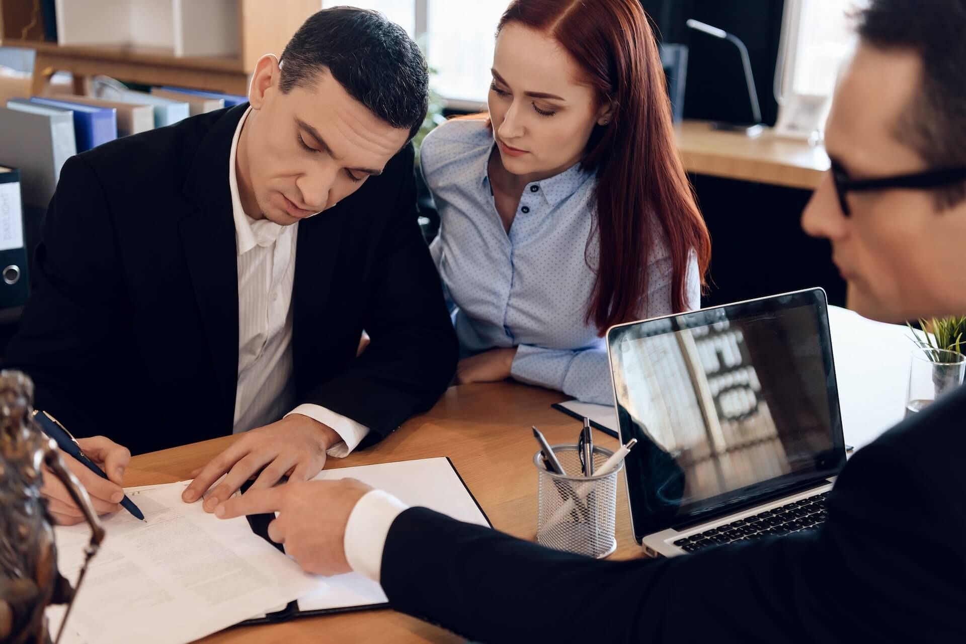 Divorce attorney shows man where to sign marriage dissolution agreement